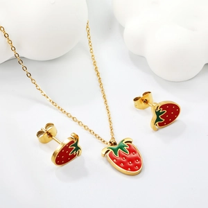 Cute red enamel strawberry jewelry set with gold necklace and earrings on white background