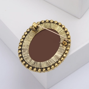 Macro view of vintage bronze oval brooch back with detailed pin clasp and texture
