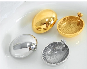 Detail of high-polished gold and silver oval stud earrings on a white tray