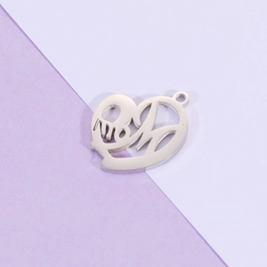 Macro shot of silver heart pendant with MOM hollow design on lilac and white background