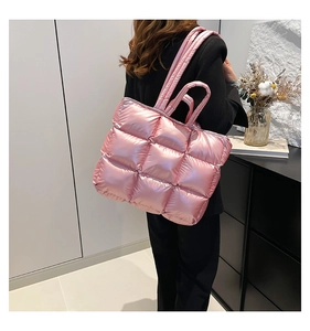 Borsa tote trapuntata rosa alla moda indossata da modella con finitura metallica lucida