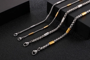 Detailed macro view of silver and gold stainless steel box chain necklaces in various sizes