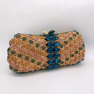 Macro shot of gold hollow-out dinner bag with colorful crystals and blue gemstones