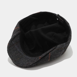 Detail view of newsboy cap lining and herringbone fabric with subtle plaid patterns