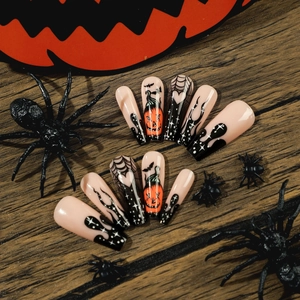 Halloween press-on nails with black spider webs, orange pumpkins and bat motifs