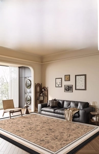 Close-up of artistic beige rug with floral sketches and black and white striped border