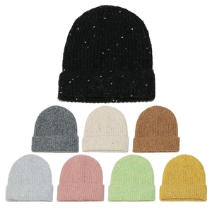 Detail view of sparkly sequin knitted beanies in various colors with ribbed wool texture