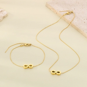 Golden infinity symbol necklace and bracelet set with snake chains on stone