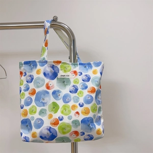 Detail of colorful watercolor polka dots printed on a white canvas tote bag