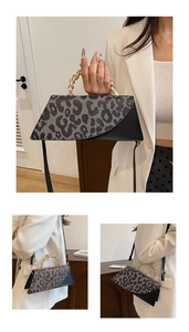 Close-up of stylish leopard print and black handbag with gold twist metal handle detail