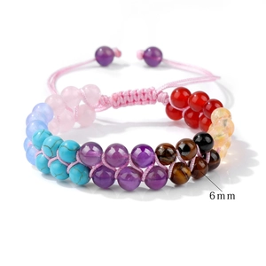 Macro detail of 6mm natural stone beads and pink hand-woven double-layer braided bracelet