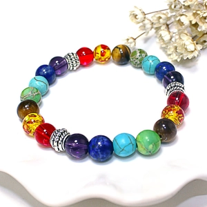 Detailaufnahme des Chakra-Armbands mit Lavasteinen auf einer weißen Keramikplatte