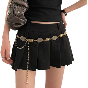Vintage gold engraved metal waist chain belt with tassel charms on black skirt