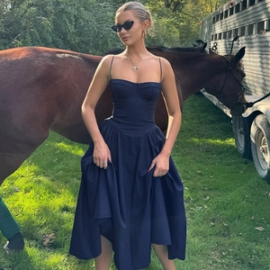 Detail of navy blue backless sundress with slim waist shown in outdoor manor setting