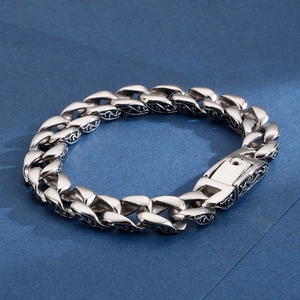 Macro detail of vintage stainless steel curb chain bracelet with engraved floral patterns
