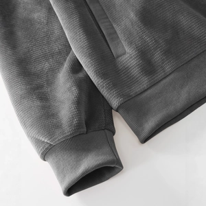 Deep charcoal gray hooded jacket with waffle knit texture and ribbed cuffs detail