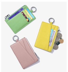 Detailed view of lychee leather coin purses in green, yellow, and pink with card slots