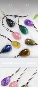 Macro view of polished natural crystal teardrop pendants with woven necklaces