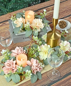 Macro detail of artificial dahlia candle ring sets with pink and beige flowers
