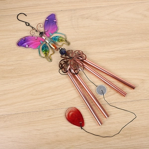 Detail of colorful butterfly wind chime with glass wings and four copper metal tubes