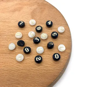 Dettaglio di perline tonde in conchiglia da 8 mm con numeri dorati per gioielli fai-da-te
