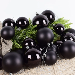 Set of matte and glossy black Christmas ornaments with evergreen and lace decor