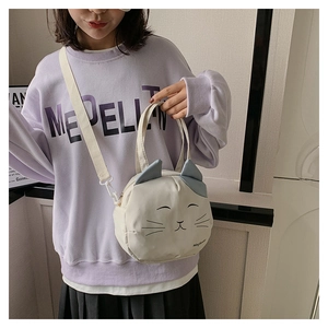 Detail of cute cat canvas shoulder bag with embroidered face and 3D ears on model