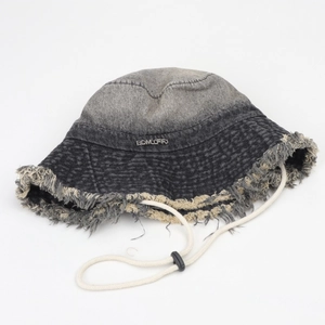 Détail du chapeau bob en denim avec bord effiloché, logo en métal et cordon réglable