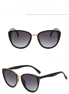 Detail view of black cat eye sunglasses with grey gradient lenses and metal frames