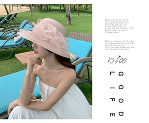 Detail shot of a pink summer sun hat with a large organza flower and fine woven texture