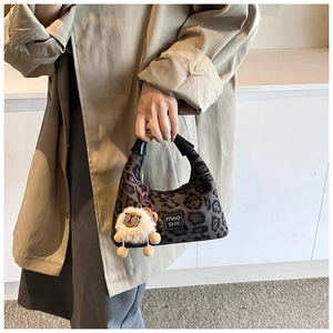 Close-up of leopard print handbag with cute sheep pendant and Miao She brand label