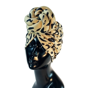 Suede-like leopard print twisted headband displayed on a black mannequin head