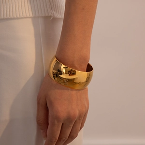 Polished gold-plated wide cuff bangle in stainless steel with open-ended design for women