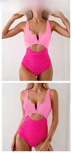 Detail of pink colorblock one-piece swimsuit featuring waist cut-outs and ruched belly design