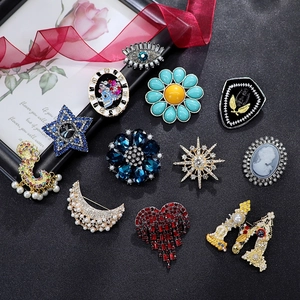Vintage style crystal brooches with pearls and colorful rhinestones on black background