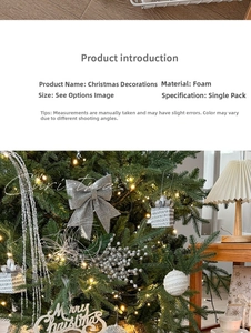 Detail of silver glitter Christmas bow and foam ornaments hanging on a festive pine tree