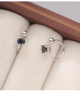 Detailed macro view of 925 sterling silver ear cuffs with black zircon in a jewelry box