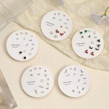 Detailed view of silver stud earring set with heart, star and butterfly shapes