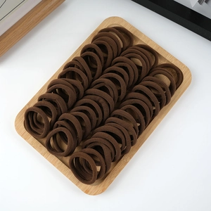 Close-up of brown thick elastic hair ties organized neatly on a wooden display tray