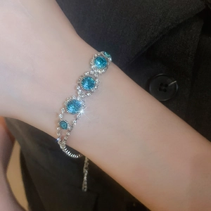 Macro detail of silver bracelet with sparkling blue round crystals on model wrist