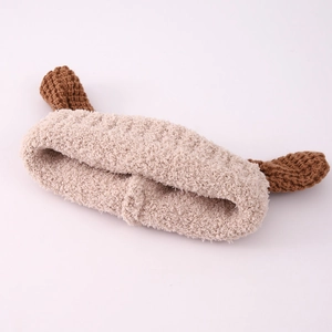 Détail macro du bandeau en peluche douce crème avec oreilles de chien tricotées marron