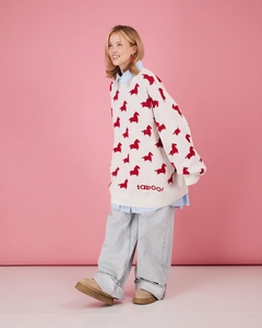 Détail du pull en tricot avec motif poney rouge et broderie taboo! sur l'ourlet