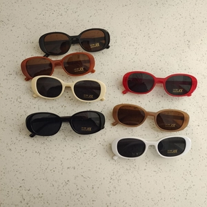Close-up of retro oval kids sunglasses in various colors with UV400 protection labels