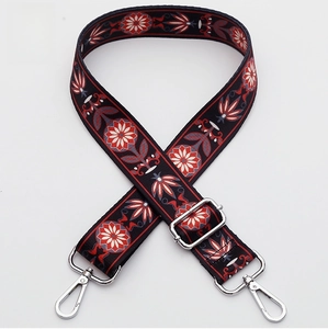 Close-up of woven bag strap with ethnic floral pattern and silver metal lobster clasps