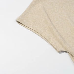Close-up detail of soft oatmeal beige knitted fabric texture for women summer set