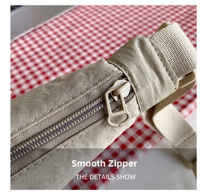 Detail of smooth matching zipper on beige nylon dumpling bag with durable stitching