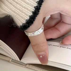 Detailed view of irregular 925 sterling silver ring with hammered texture on thumb