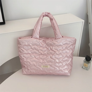 Detail of pink heart-quilted tote bag with Suzakka label and puffer texture