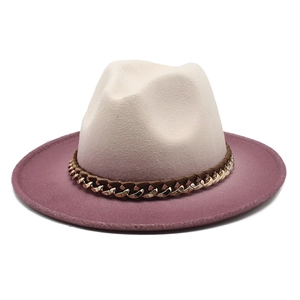 Detail of felt fedora hat featuring beige crown, purple wide brim, and metal chain trim