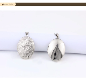 Detail of silver oval locket necklaces with floral engraving and polished mirror finish